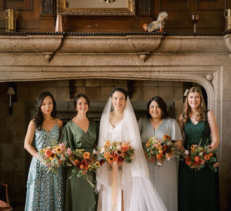 Bridesmaids in green mismatched bridesmaid dresses for the classic wedding day with the bride 