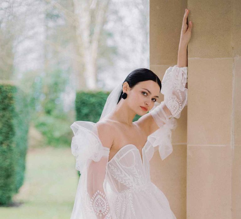 Bride in sweetheart neckline tulle mesh bridal gown with detachable puff tulle sleeves and delicate beading with cathedral length veil at Settrington Orangery 