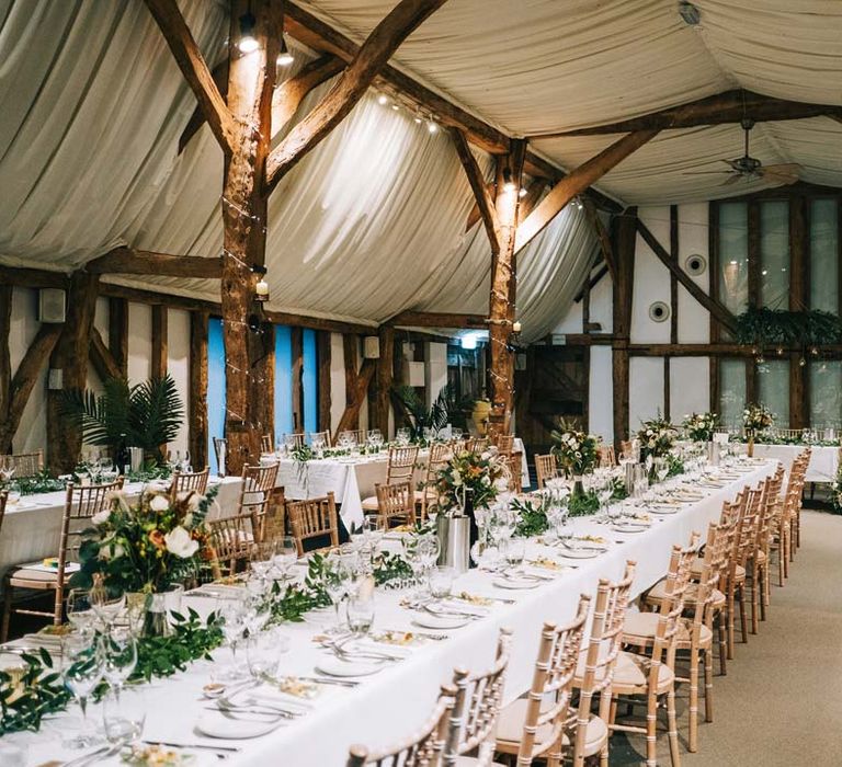 South Farm wedding reception room with classic rustic wedding tablescape - white tablecloth, foliage wedding table runners and pampas grass, eucalyptus, blush garden roses, dried flowers and foliage floral centrepieces 