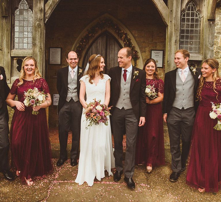 Wedding party for October Ramster Hall wedding with the groom and groomsmen in morning suits and the bridesmaids in burgundy dresses 