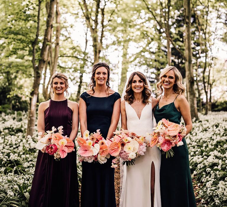 Bridal party wearing dark jewel tone bridesmaid dresses