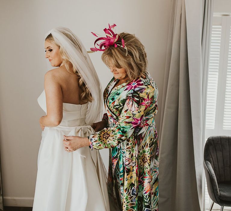 Bride in strapless Eva Lendel wedding dress with the mother of the bride in colourful patterned outfit 