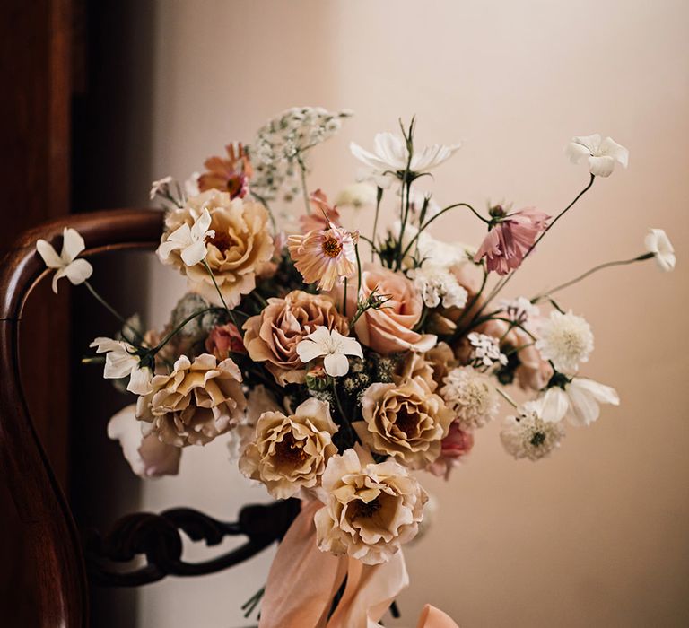 cafe au lait and blush pink wedding bouquet on a chair