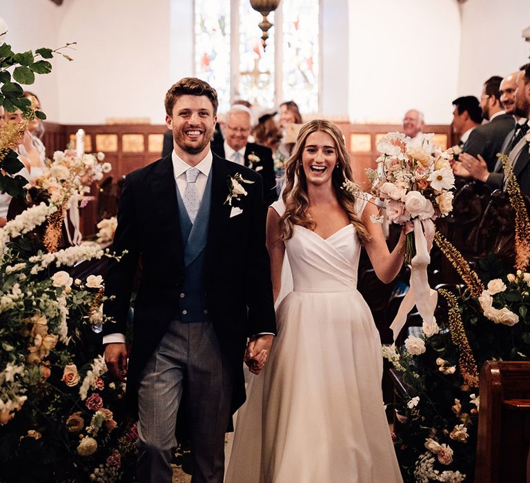 classic church wedding ceremony with bride in a Suzanne Neville wedding dress and groom in a morning suit 