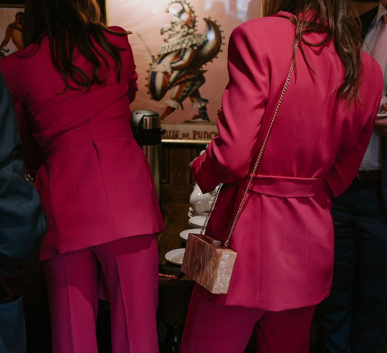 Groomswomen wearing hot pink suits for bright and vibrant wedding 