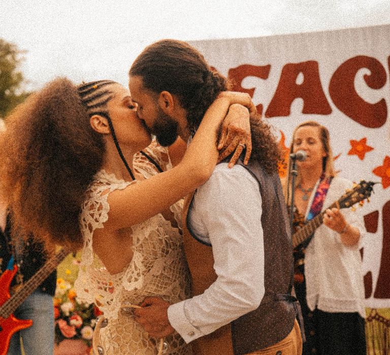 Bride in boho crochet gown with the groom in a brown linen suit at vintage retro wedding inspired by the 60s and 70s 