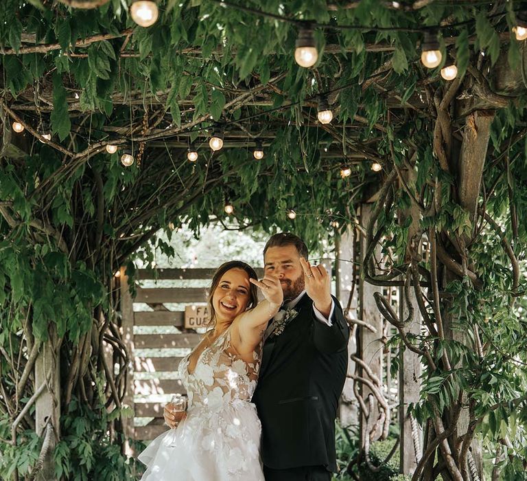 Bride and groom sticking their ring fingers up