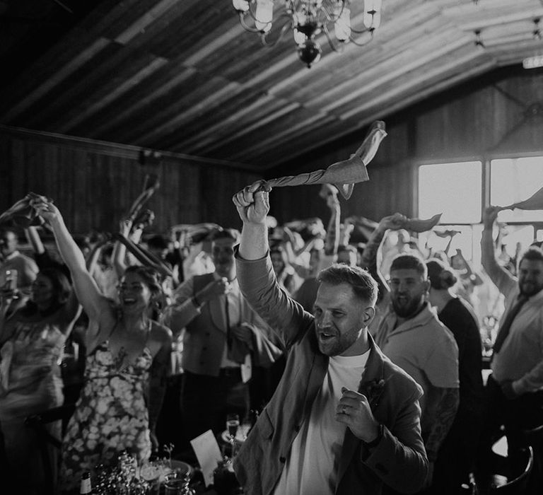 The guests raise their glasses in a toast during the wedding speeches 