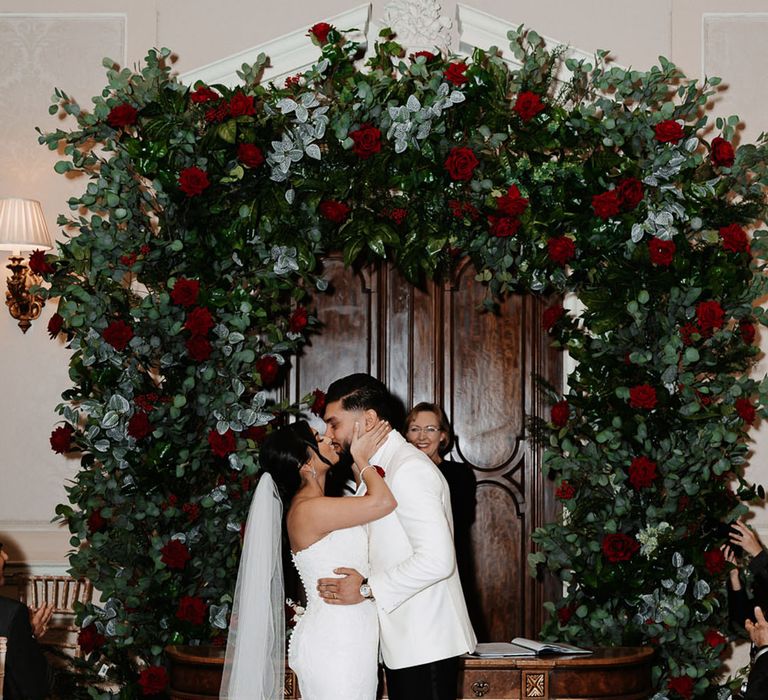 Snowy winter wedding at country house wedding venue, Hedsor House with red rose flower arch 