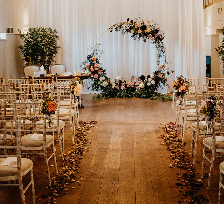 Rustic barn wedding venue in Hertfordshire with pink floral moongate altar decoration for rustic wedding 