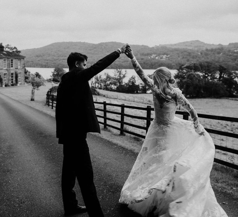 Groom spins the bride around as they pose for their couple portraits 