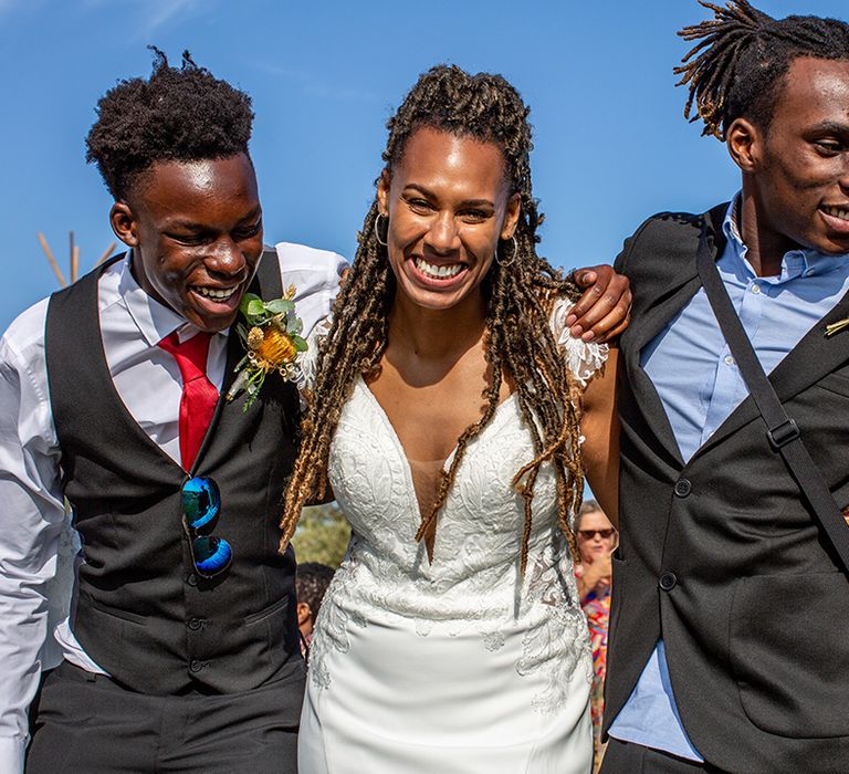 Bride stands laughing with wedding guests 