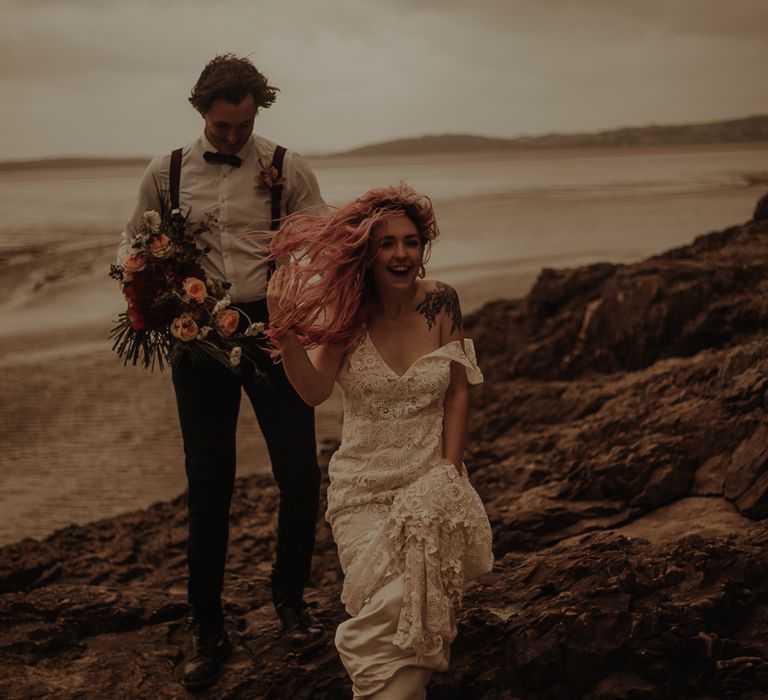 Bride with pink hair blowing in the wind at beach elopement