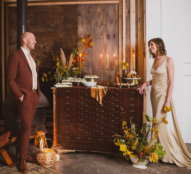 Bride and groom standing by dessert table