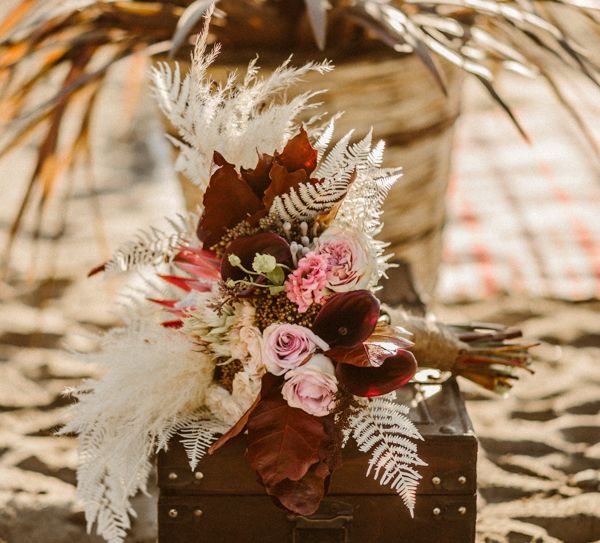 Wedding bouquet with pink flowers, leaves and dried grass