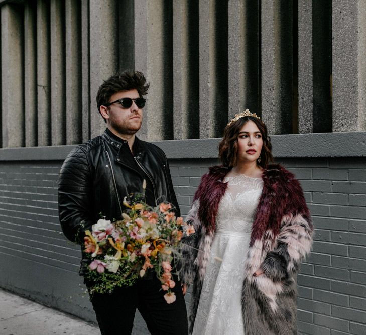 Groom carries bouquet of Autumnal floral blooms