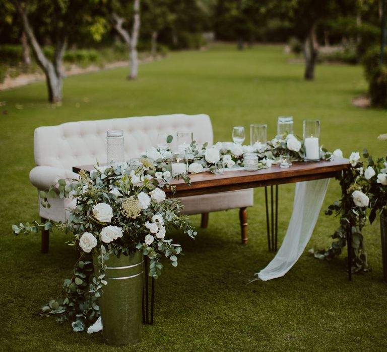 The bride and groom looked over the outdoor dance floor from a loveseat