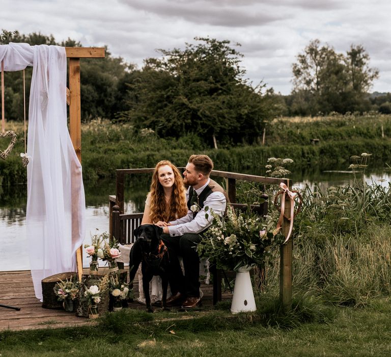 Bride & groom during their wedding ceremony surrounded by floral bouquets 