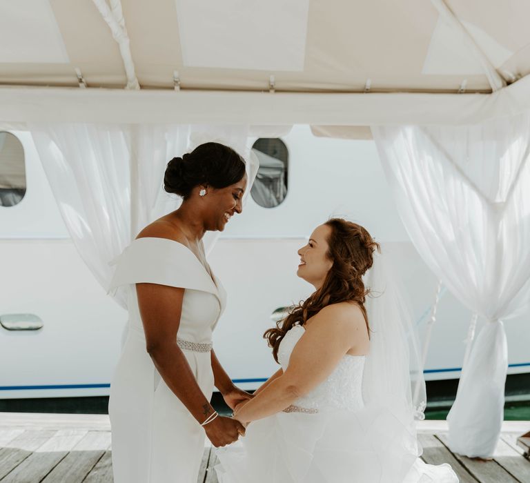 Two brides holding hands during their first look photo session