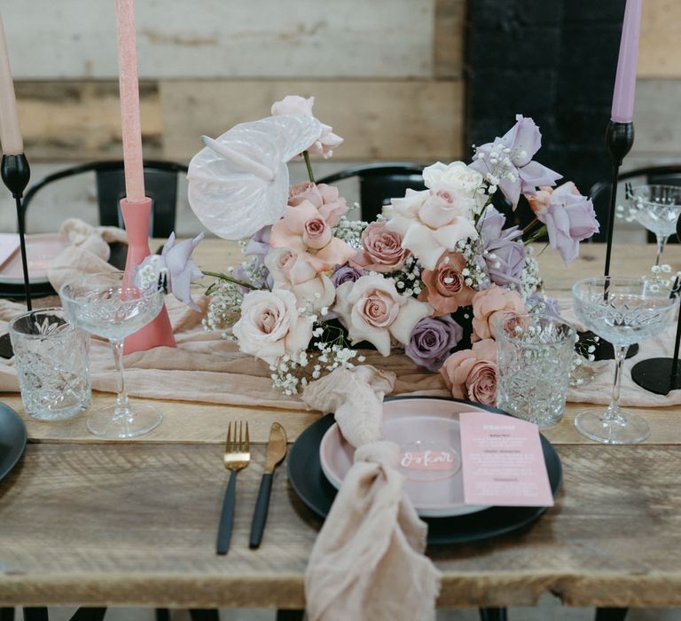 Table decor with black and glass tableware and pastel pink and purple wedding decor ideas