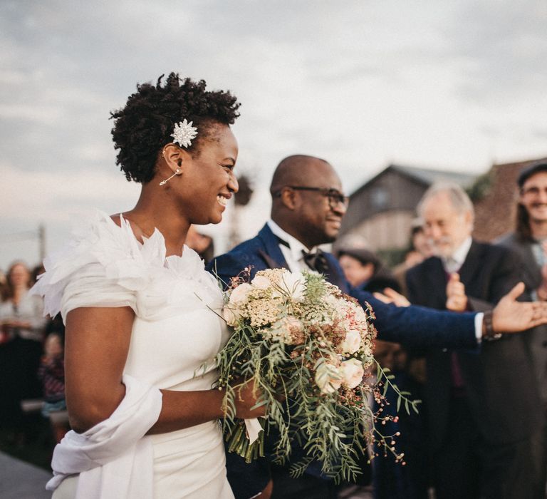 West African bride with short hair in a Georges Hobeika wedding dress with feather shoulder detail 