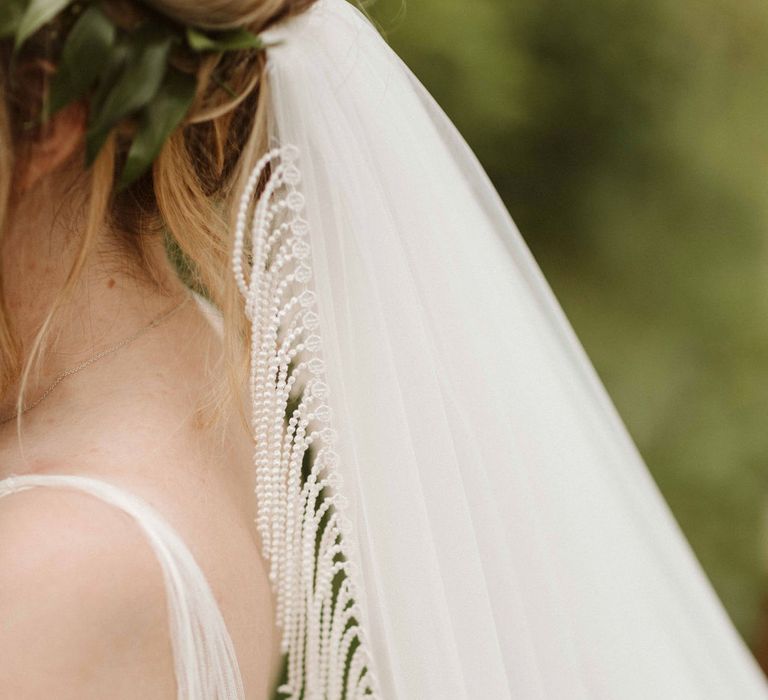 Bride wears floor length veil with fringed edge