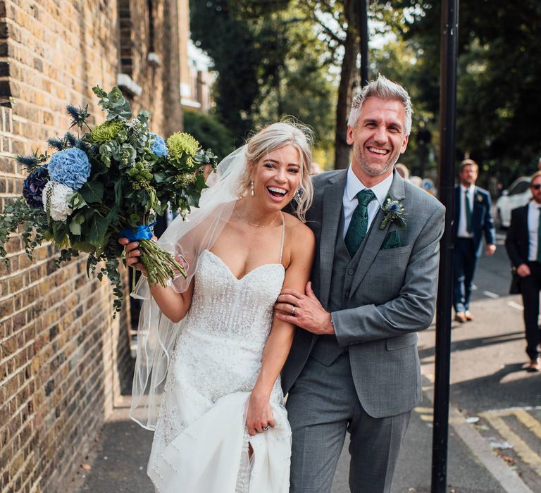 Bride & groom walk together through London after wedding ceremony