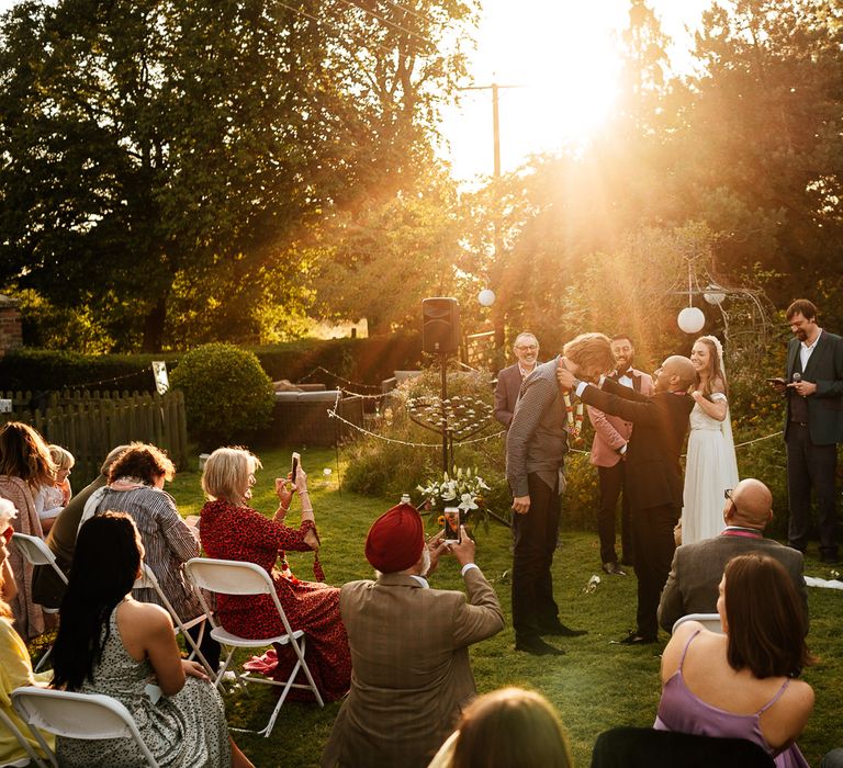 Sunlight shines through the trees during golden hour in outdoor ceremony