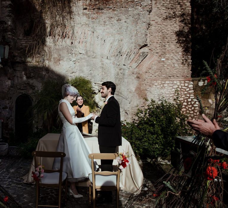 The bride and groom standing at the altar of their Rome micro-wedding ceremony