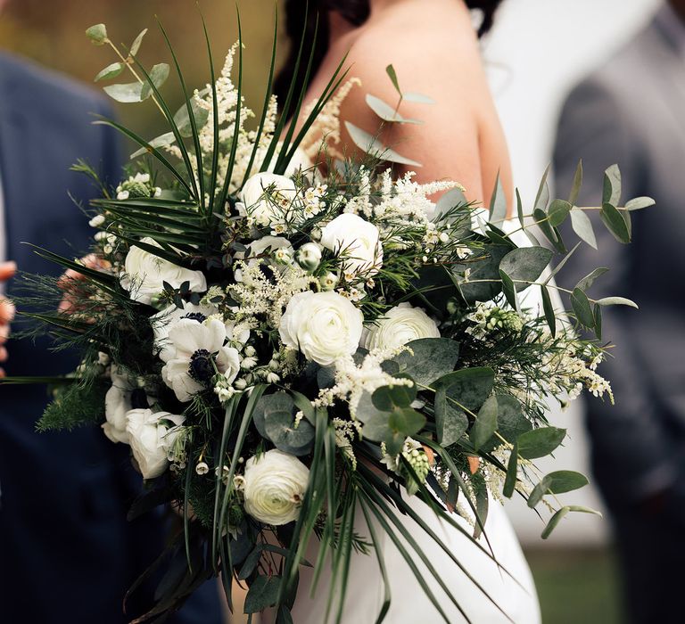 White and green botanical wedding bouquet with roses, palm leaf and foliage