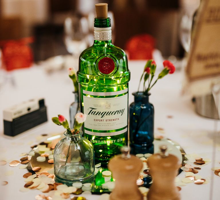 Gin bottle sits in the middle of table for tablescape for wedding reception