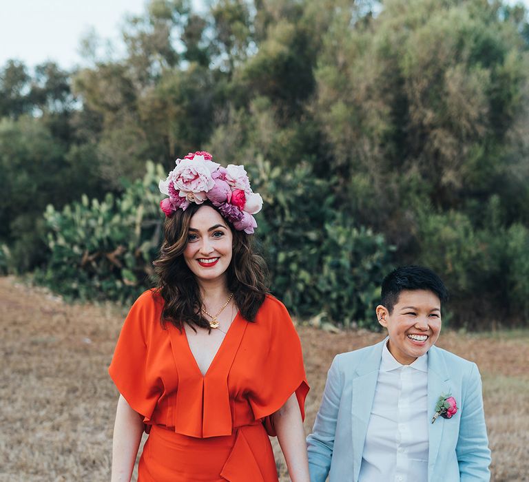 Brides stand together and hold hands for post-wedding photoshoot in Menorca