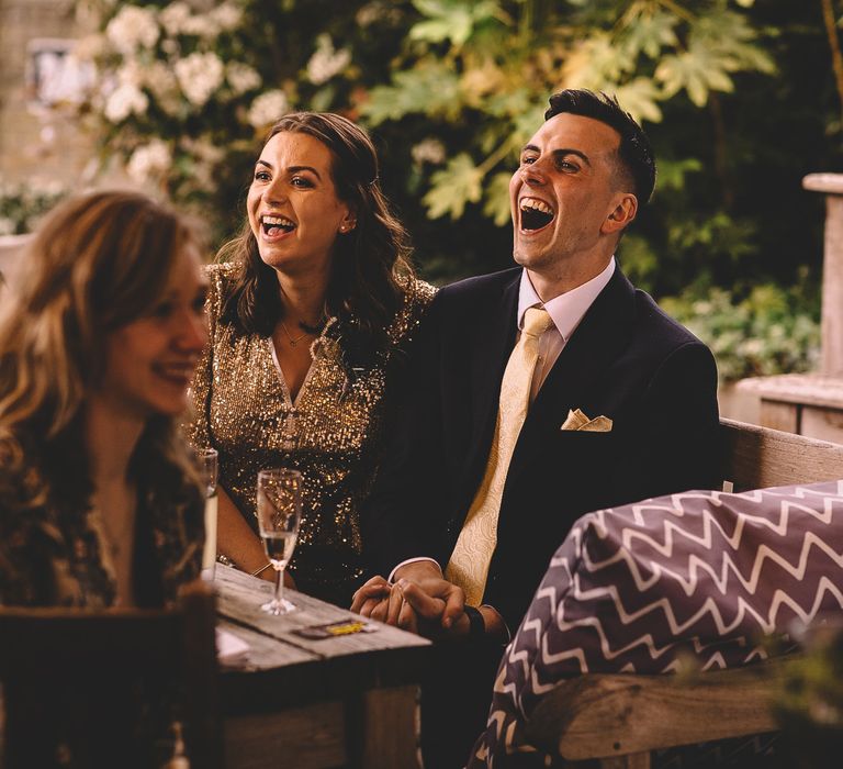 Wedding guests laughing during the intimate pub wedding reception speeches 