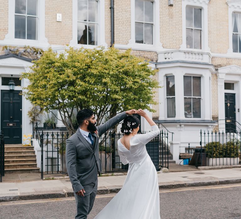 Bride & groom walk through Chelsea as groom spins his bride around in the street