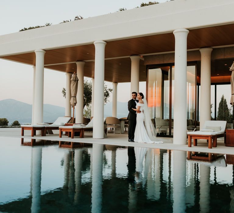 Bride & groom stand behind bright blue pool at Villa 20 on their wedding day | Hannah MacGregor Photo & Film