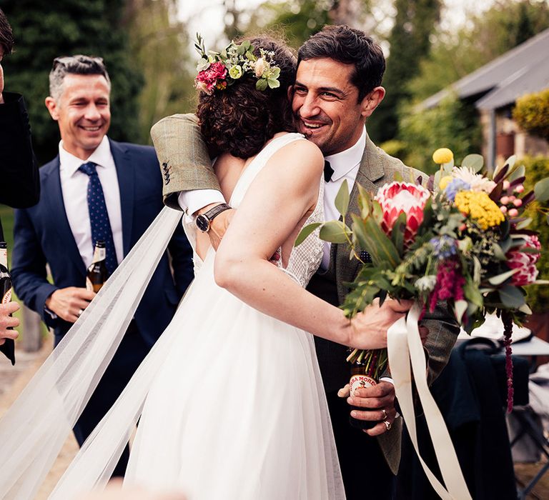 Bride in Riley dress Made With Love bridal hugs wedding guest