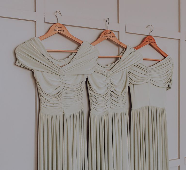 Pale green bridesmaids gowns with off the shoulder short sleeves and pleated skirts