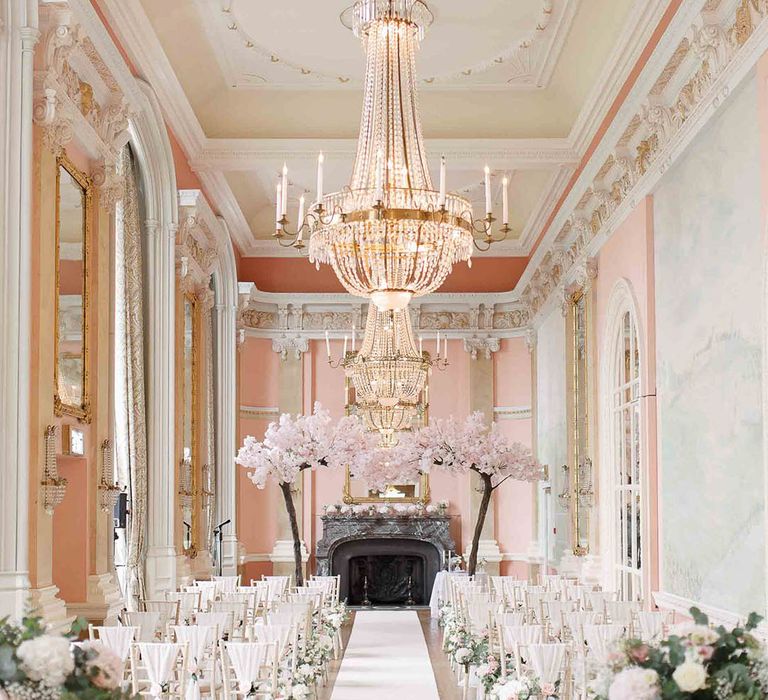 Danesfield House complete with blossom tree archway, grand chandelier and white seats with white bows 