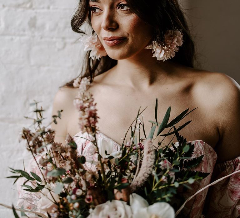 Boho bride with natural wedding makeup and blush pink dried flower hair accessory and hoop earrings 