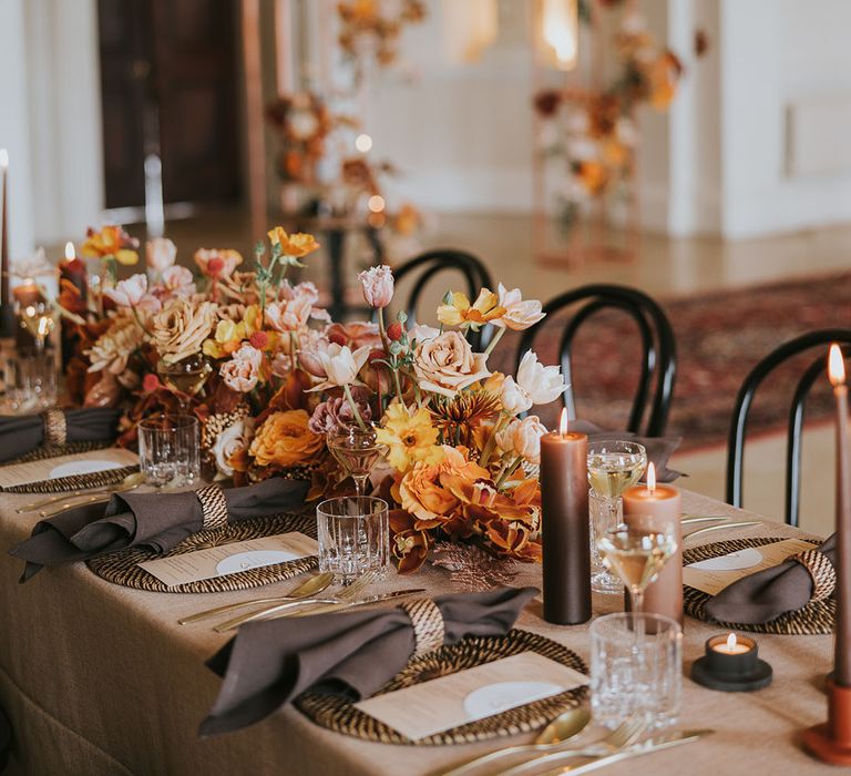 Wedding reception table decor with orange and natural wedding flowers and decor at Kirtlington Park 