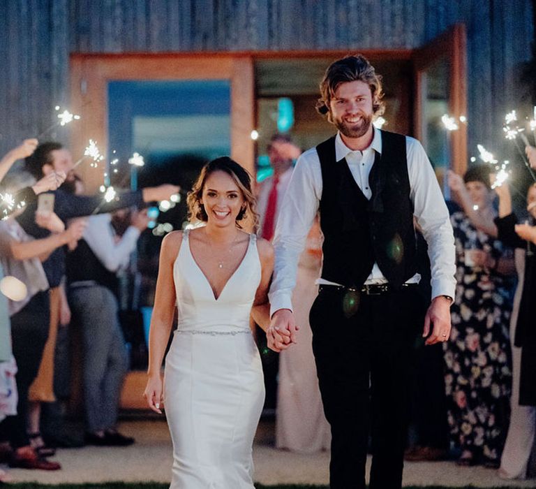 Bride and groom walking down an aisle of sparklers at Elmore Court