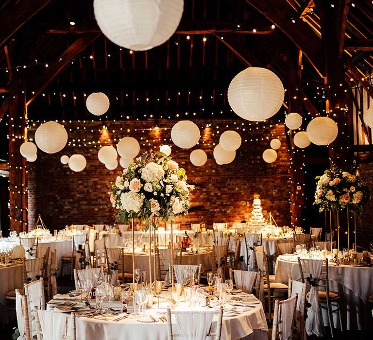 Cooling Castle wedding venue reception layout with white paper lanterns with tall centrepieces with white and pink roses 