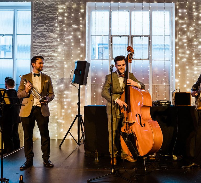 Live entertainment wedding band on stage in front of fairy lights 