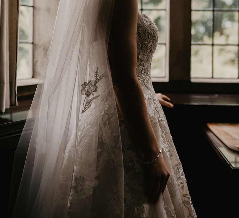 Bride in lace sweetheart wedding dress with lace detail and veil with similar lace detailing 