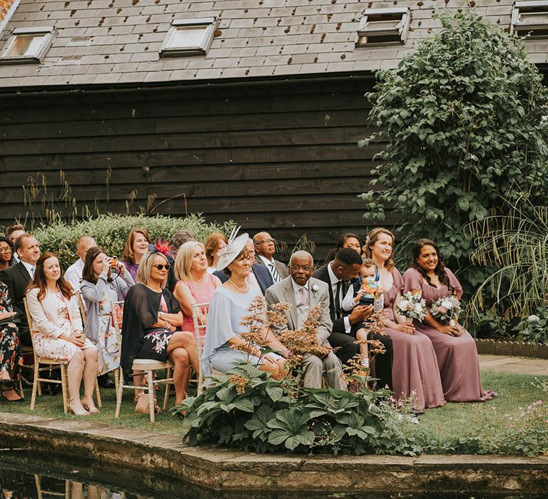 Wedding guests sit outside Micklefield Hall for outdoor wedding 