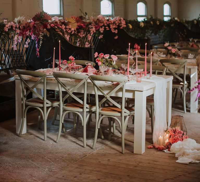 Prestwold Hall Barn wedding reception with pink taper candles, pink flowers, cherry blossom installation and wooden furniture 