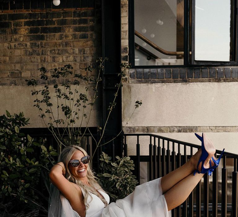 Intimate London wedding with bride in a princess wedding dress, blue shoes and sunglasses 