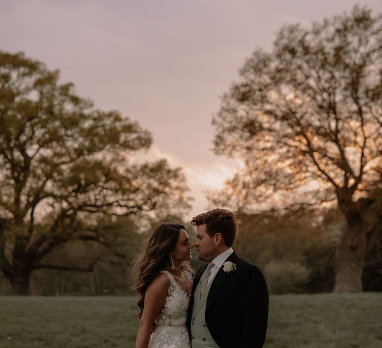 Groom in morning suit with green waistcoat, floral tie and puppytooth trousers with bride in Mira Zwillinger flora applique wedding dress 