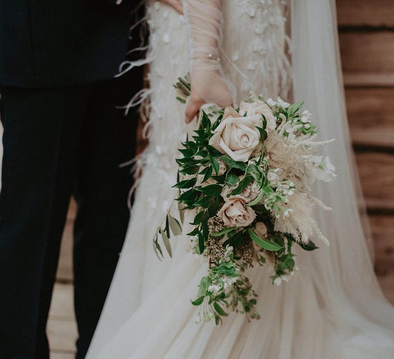 Bridal wedding bouquet with a  neutral colour palette including roses and dried grass