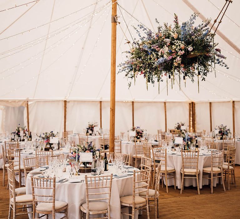 The One Six Events marquee with fairy lights and large pink and blue wedding flower cloud decor with circular tables 